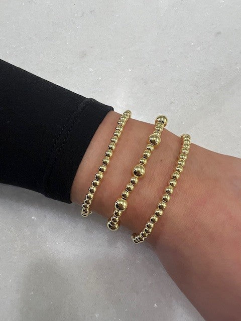 Three large gold beaded bracelet set