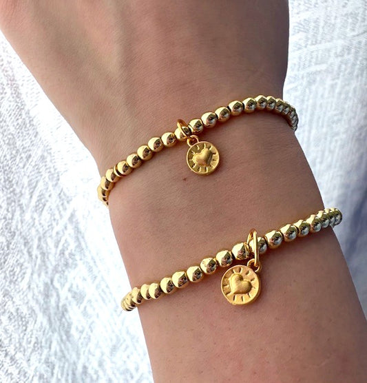 Two gold beaded bracelet set with heart charms